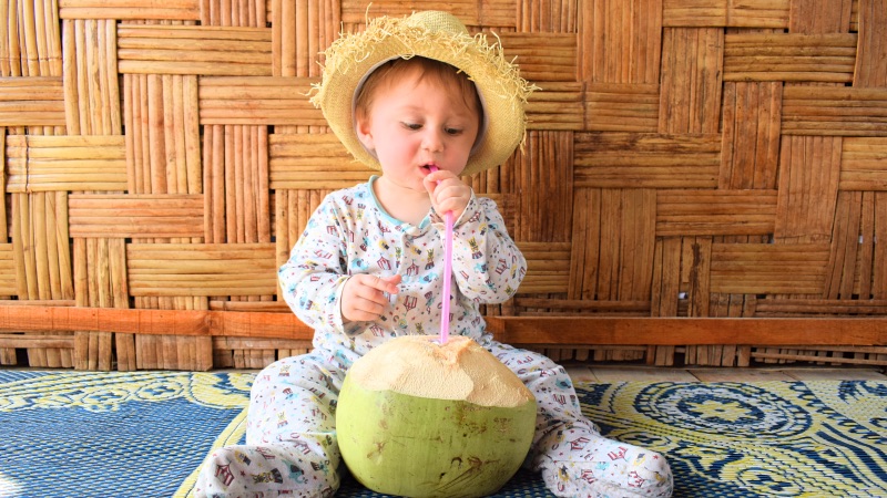 Baby drinking a coconut